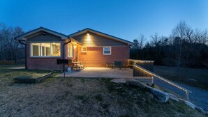 A brick house with a patio, a covered seating area, and a staircase leading to a deck. - JB`s Place - One Home with Two Living Spaces! (Brevard)