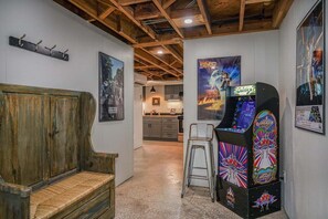 Una habitació amb una banca de fusta, una màquina recreativa i un pòster de Star Wars.