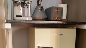 A compact kitchen with a refrigerator, a coffee maker, and a toaster. - Impeccable 1-Bed Apartment in Birmingham (Birmingham)