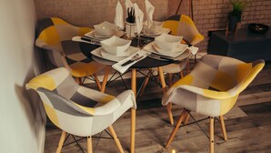 A dining area with a brick wall, round table, and modern chairs. - Impeccable 1-Bed Apartment in Birmingham (Birmingham)