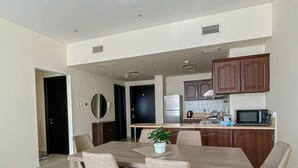 A modern kitchen with dark wooden cabinets, a stainless steel refrigerator, and a microwave.