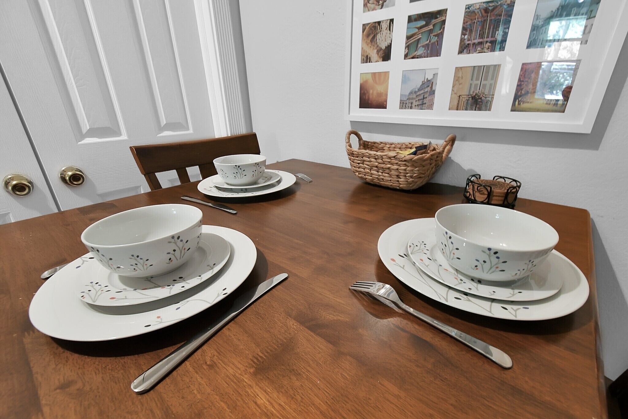 A dining table set with white plates, bowls, and cutlery.