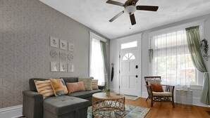 A living room with a grey sofa, a round coffee table, and a patterned rug. - Modern Boho🪴Style 1BR Near DT on Historic Street (Columbus)