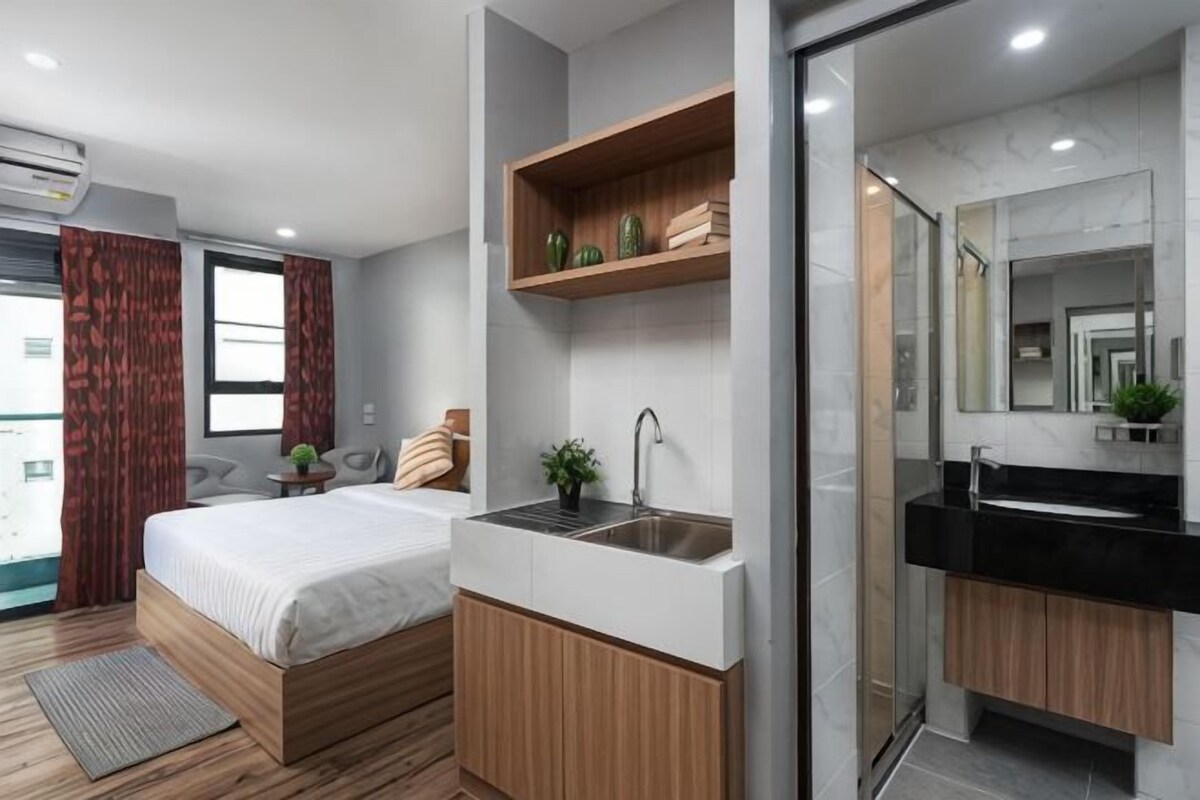 Une chambre à coucher moderne avec un lit, une table de chevet et un lavabo intégré.