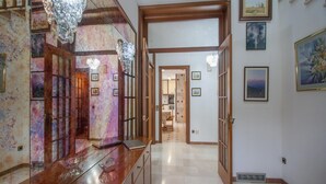 Un passadís amb un taulell de fusta, un mirall i una porta que dona a una habitació.