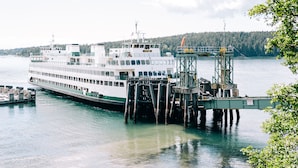 Un traversier accosta à un quai, lequel était relié au rivage par un pont.