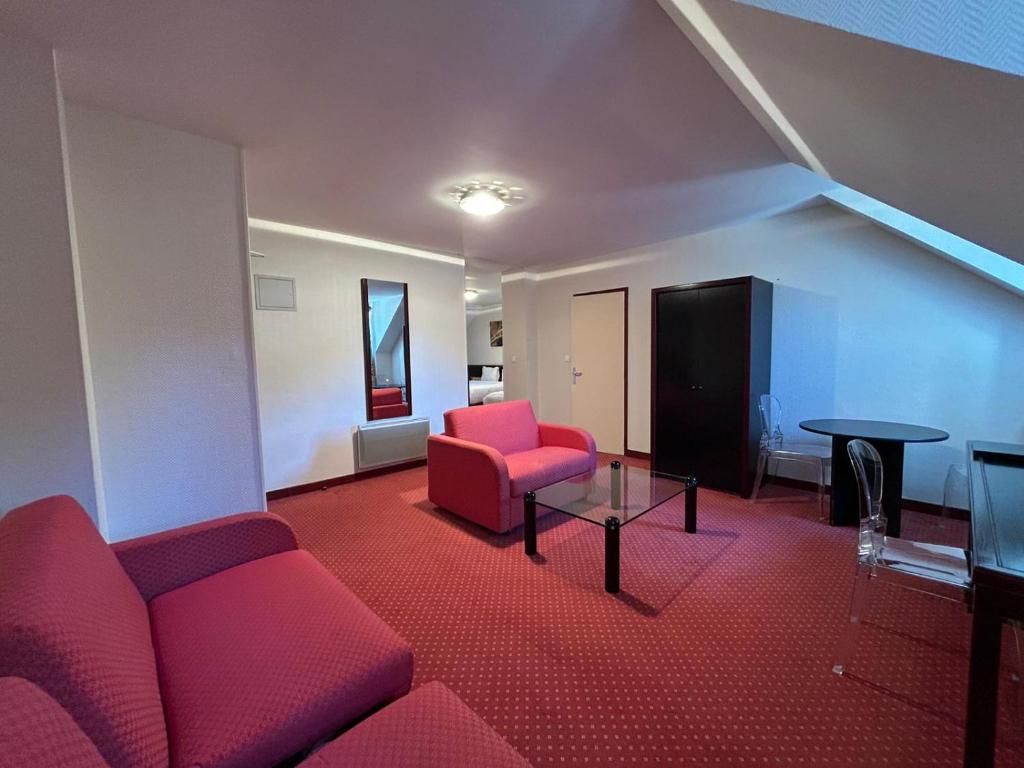 Ein modernes Wohnzimmer mit roten Sofas, einem Glastisch und einer schwarzen Kommode.