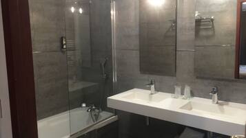 A modern bathroom with a glass-enclosed shower, a double sink vanity, and a large mirror.