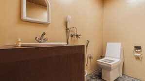 Un baño con lavamanos, espejo, ducha e inodoro.