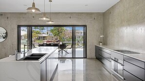 Una cocina moderna con una isla grande, electrodomésticos de acero inoxidable y vistas al exterior.