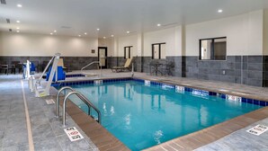 An indoor swimming pool with clear lane markings, a diving board, and lounge chairs. - Comfort Suites Paducah Mall Area (Paducah)