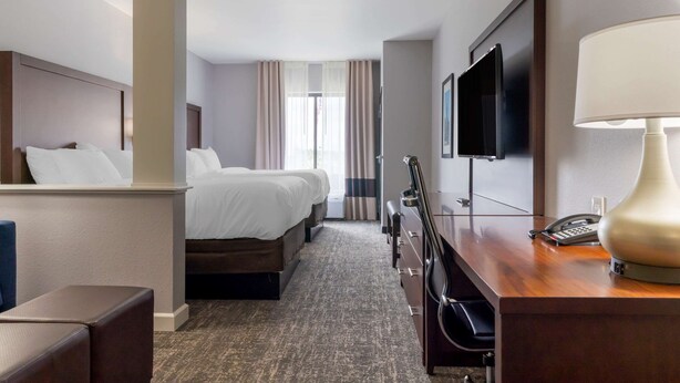 A hotel room with a bed, a desk with a lamp, a TV, and a phone. - Comfort Suites Paducah Mall Area (Paducah)