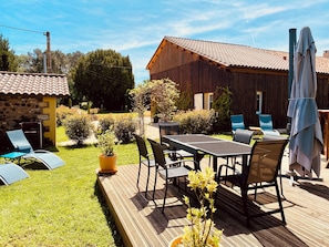 A wooden deck with outdoor furniture, a table, and chairs. - Holiday Home with Aircon and Private Heated Pool - 40 Minutes from Bergerac (Capdrot)