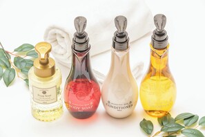 Four bottles of body care products: foam soap, body soap, conditioner, and shampoo.