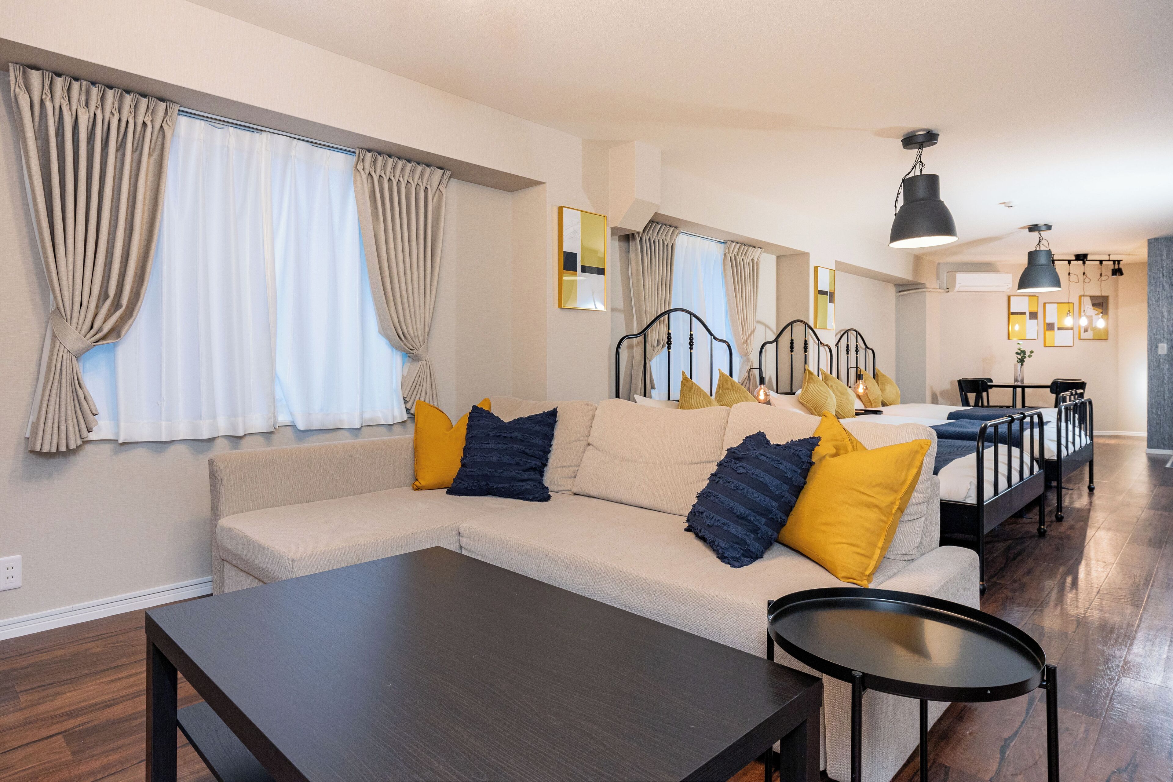 Uma sala de estar moderna com sofá, mesa de centro e área de jantar com mesa e cadeiras.