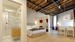 A modern bedroom with a wooden ceiling, a bed, a desk, and built-in shelving. - Monti Panisperna Suites (Rome)