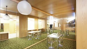 Un interior moderno con paredes espejadas, alfombra con estampado verde y muebles contemporáneos.