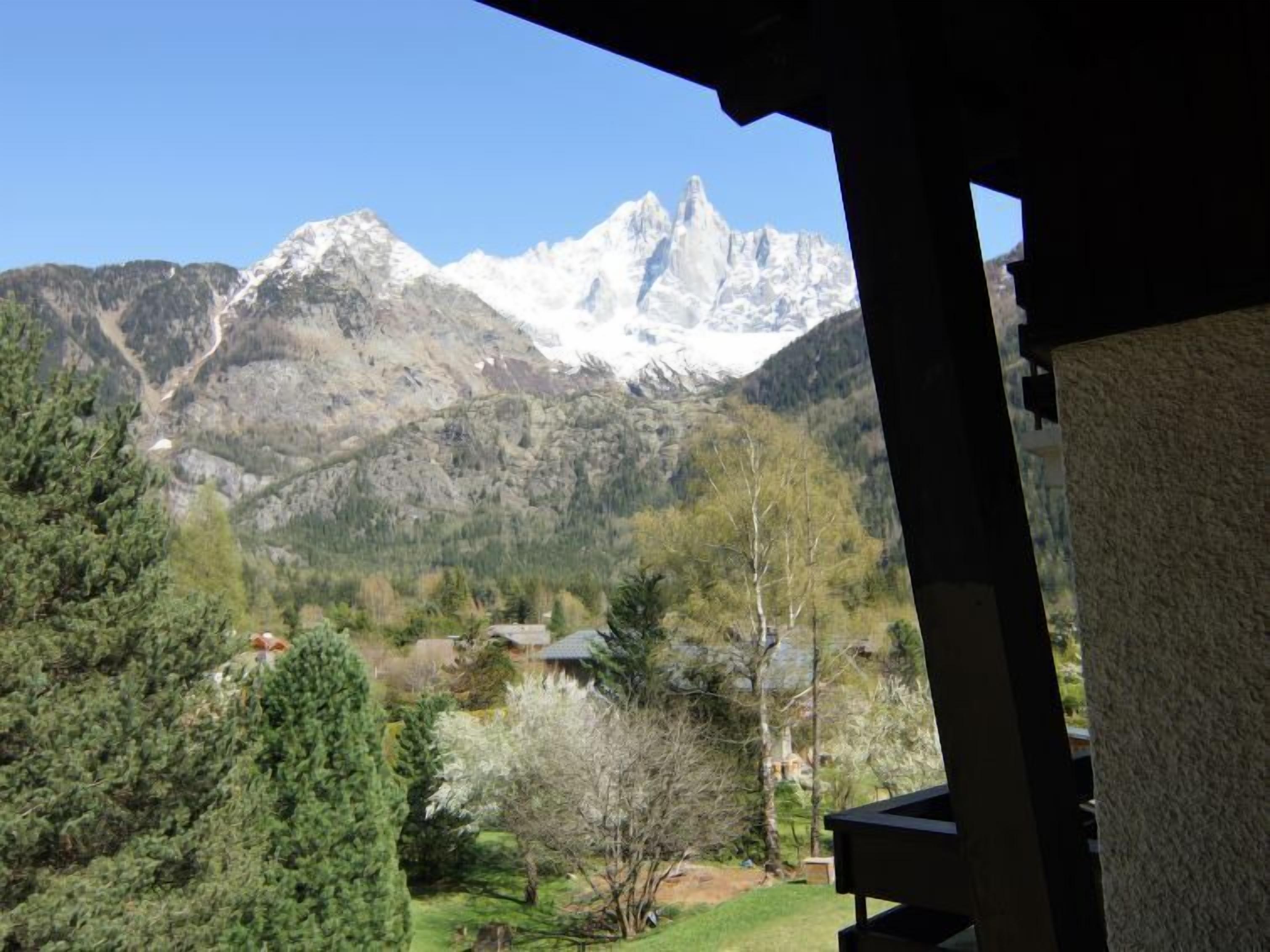 Une vue sur les montagnes depuis un bâtiment, avec un ciel dégagé.