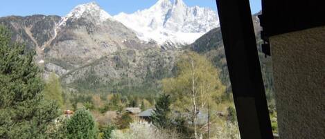 Une vue sur les montagnes depuis un bâtiment, avec un ciel dégagé.