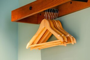Wooden hangers hanging from a wooden beam.
