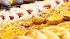 Gros plan d’un plateau de desserts présentant divers produits de boulangerie, notamment des tartes et des pâtisseries, dont certaines sont garnies de fruits.