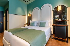 Une chambre d’hôtel avec un grand lit, une machine à café et un petit réfrigérateur.