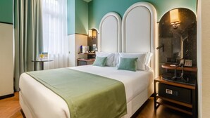 Une chambre d’hôtel avec un grand lit, une table de chevet avec une lampe, un miroir et un téléphone.