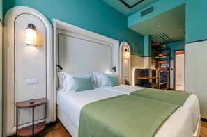 A modern hotel room with a large bed, a bedside table, a wardrobe, and a mirror. - Nicola Rossio Hotel (Lisbon)