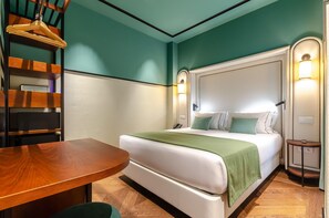 A hotel room with a bed, bedside table, lamp, and a wooden chair. - Nicola Rossio Hotel (Lisbon)