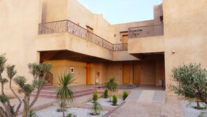 A courtyard with a central staircase, small trees, and a fire extinguisher. - SUMAHAN SUITES & SPA (Tameslouht)