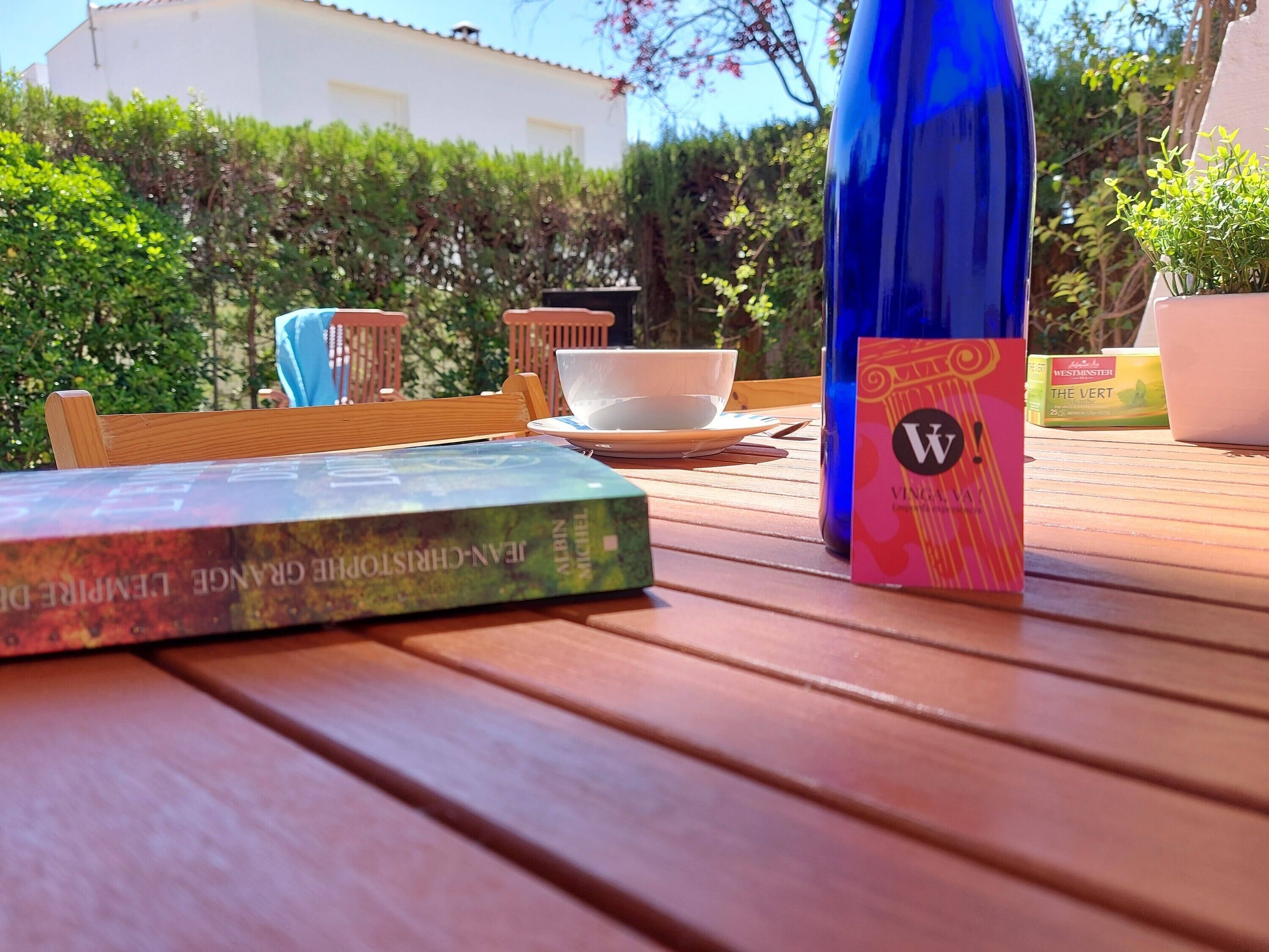 Una taula de fusta amb un llibre, una ampolla i una caixa de te.