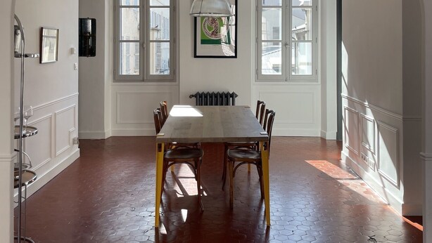 A dining area with a large table, chairs, and a hanging light fixture. - Center, charm, comfort, Clim, shops, restaurants, transport, outings, pkg. (Toulon)