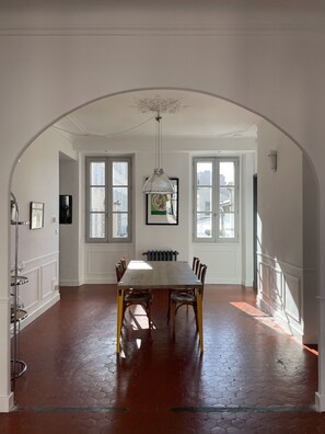 A dining area with a large table, chairs, and a hanging light fixture. - Center, charm, comfort, Clim, shops, restaurants, transport, outings, pkg. (Toulon)