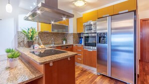A modern kitchen with granite countertops, stainless steel appliances, and wooden cabinets.