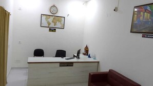 A reception area with a desk, chairs, a clock, a world map, and a 'No Smoking' sign. - Hotel CityMax Inn (Greater Noida)