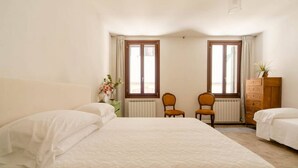 Ein Schlafzimmer mit einem großen Bett, zwei Stühlen, einer Kommode und einem Heizkörper.