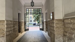 A hallway with stone walls and a tiled floor leading to a gated entrance. - Beautiful apartment a short distance from Saint-Pierre (Roma)