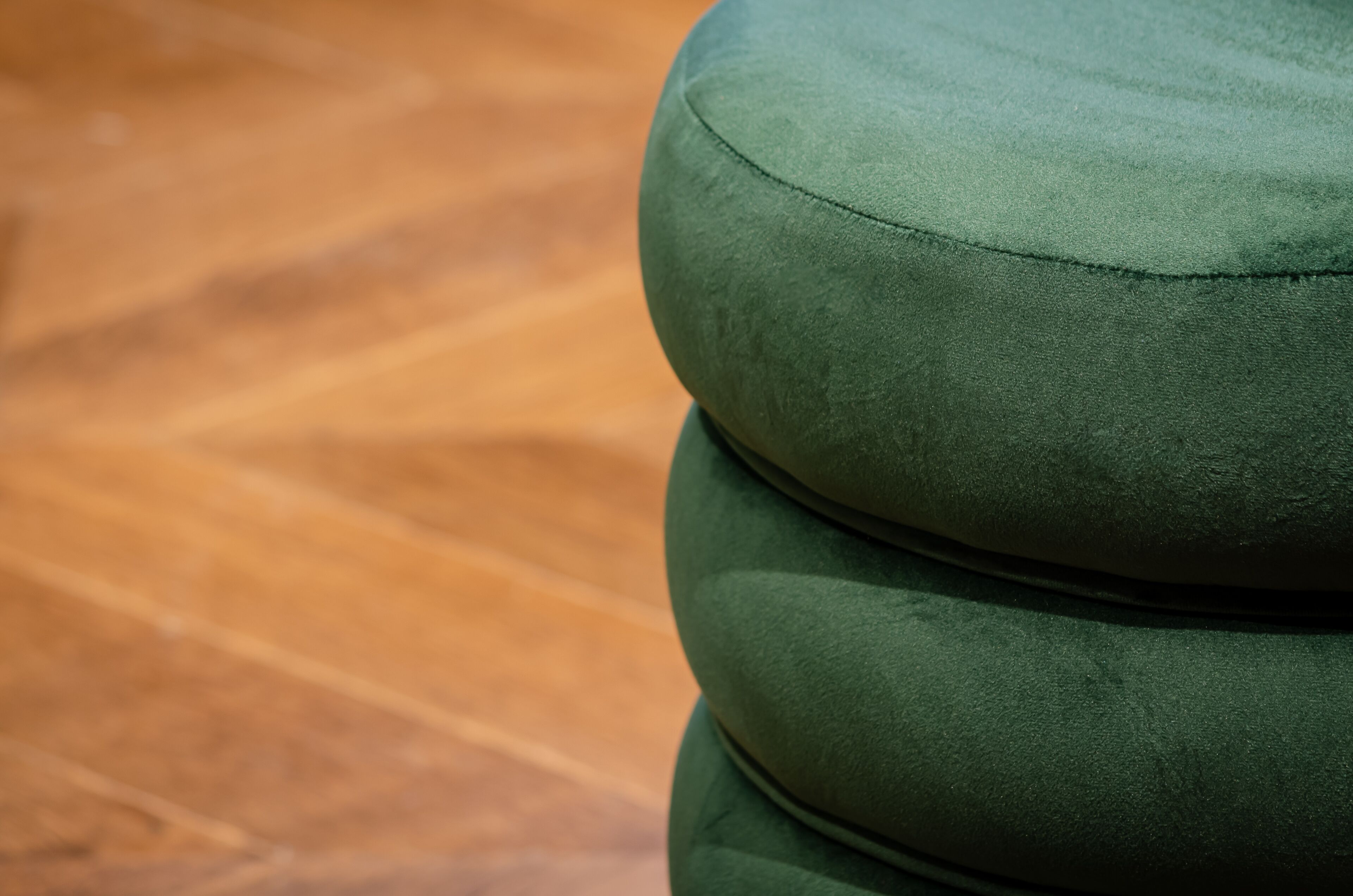 A close-up of a green upholstered seat with a visible seam.