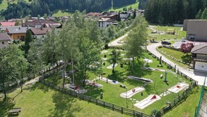 Un parcours de golf doté d’une zone délimitée par une clôture, d’un pavillon et d’un bâtiment portant l’inscription « MINIGOLF ».