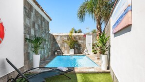A swimming pool with two lounge chairs and a small grassy area. - Casa Bombón - Country House with Private Pool & Wi-Fi – Families Only (Vejer de la Frontera)