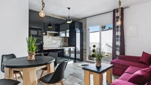 A modern apartment with a dining area, kitchen, and living room. - Casa Bombón - Country House with Private Pool & Wi-Fi – Families Only (Vejer de la Frontera)