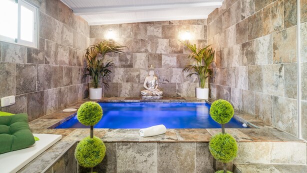 A spa area with a meditation statue, a blue pool, and potted plants. - Casa Bombón - Country House with Private Pool & Wi-Fi – Families Only (Vejer de la Frontera)