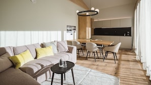 Una sala de estar moderna con un sofá, una mesa de centro y un comedor con sillas.