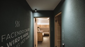 Un pasillo con un letrero que dice 'FACENDO CALDO WIRDSHEISS RATING HOT HERE' y vista a una habitación con una cama y una lámpara.
