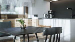 Cuina moderna amb zona de menjador, cafetera i finestra amb vista.