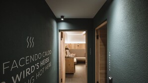 Un passadís amb un cartell que diu 'FACENDO CALDO WIRDSHEISS RATING HOT HERE' i una vista d'una habitació amb un llit i una làmpada.