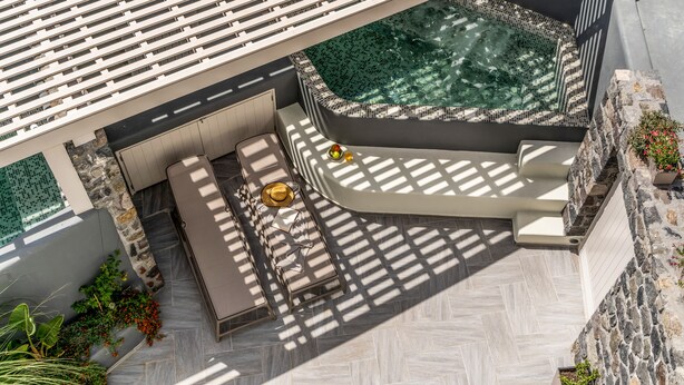 Una terraza en la azotea con un jacuzzi, zona de estar y vistas de la ciudad.