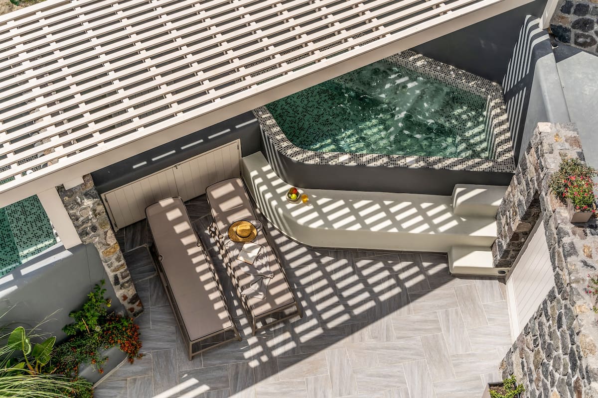 A rooftop terrace with a hot tub, seating area, and a view of the city.