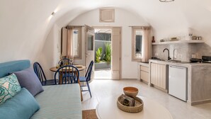 Un espacio habitable compacto con kitchenette, comedor y sofá.