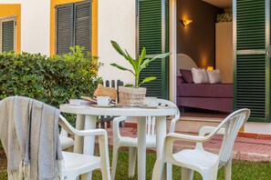 Une table ronde avec des chaises, une plante en pot et un panier.